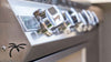 Angled close-up of the KoKoMo grill badge, polished control knobs and palm-tree cutout