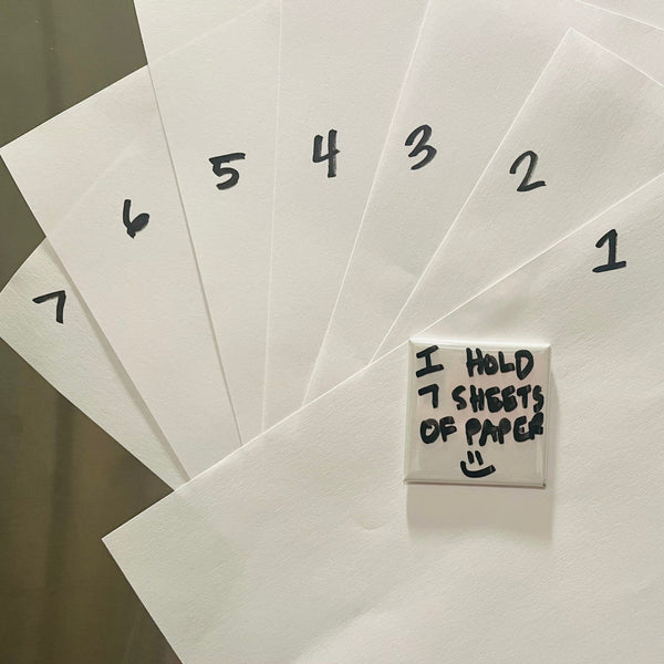 Close-up of Nana Mode fridge magnet holding 7 sheets of paper, showing high-performance magnetic strength