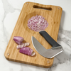 NULU bamboo cutting board with chopped onions in its built-in mincing bowl and a curved NULU knife resting alongside