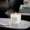 Close up of candle flame with botanical accents in the background