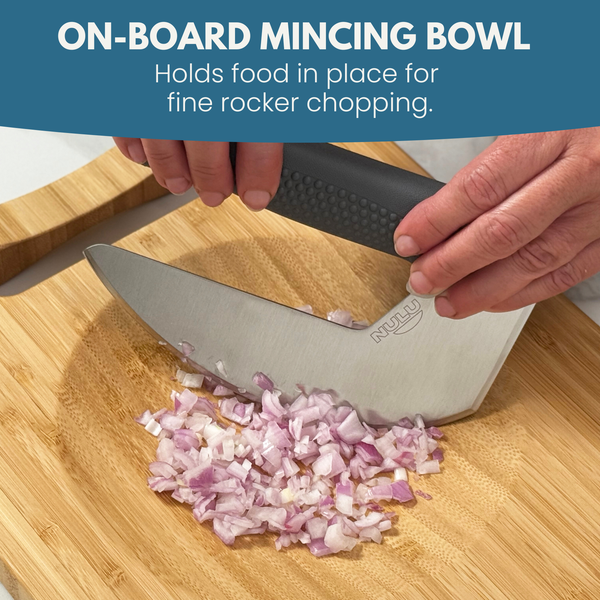 Hands using a curved NULU knife to mince onions in the cutting board’s recessed bowl