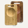 NULU bamboo and acacia cutting boards side by side, each with a recessed mincing bowl and carrying handle