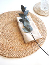 "Minimalist dining setting featuring Kara natural placemats and ceramic plates"
