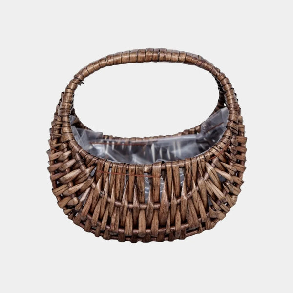 Half-moon wicker basket used as an indoor plant holder with integrated clear protective liner