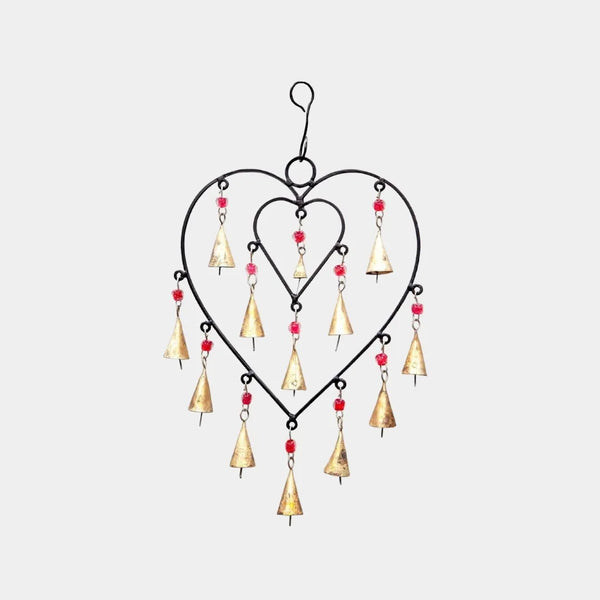 Close-up of upcycled iron and brass heart chimes showing rustic artisan texture