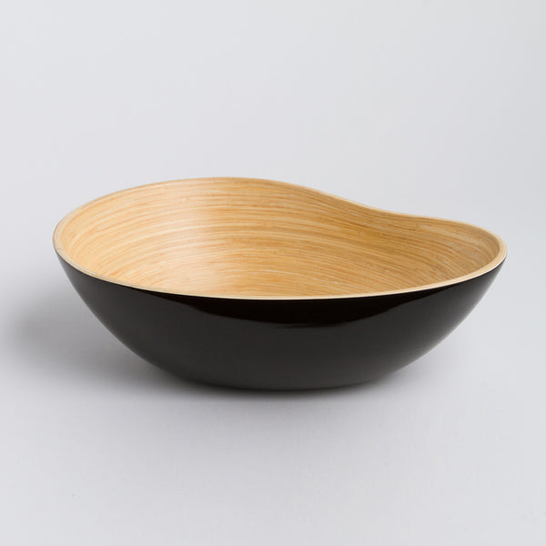 Bowl with black exterior and wooden interior on a light gray background