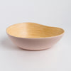 Bowl with beige interior and pink exterior on a light gray background