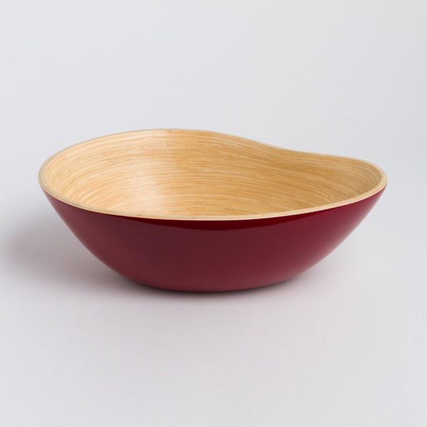 Bowl with red interior and wooden exterior on a light gray background