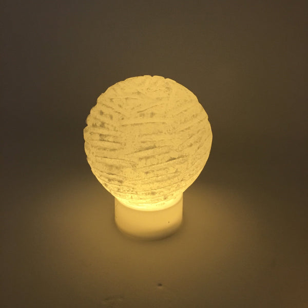 Selenite bubble lamp glowing on a nightstand, calming ambient light for peaceful bedroom decor