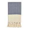 Towel with blue and white chevron pattern and beige tassels on a white background