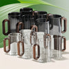 Set of glass mugs with wooden handles on a light background