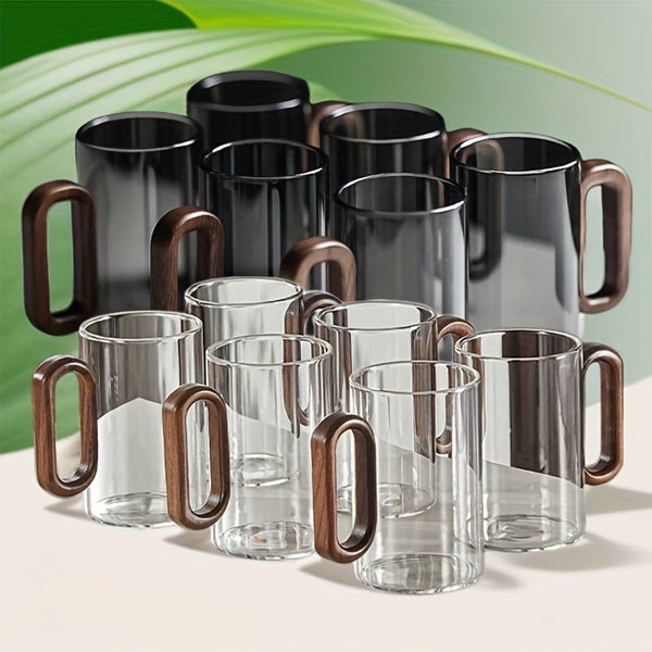 Set of glass mugs with wooden handles on a light background