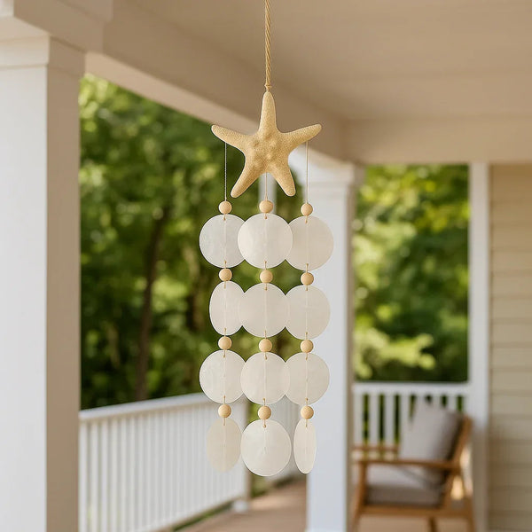 Bohemian seashell wind chime hanging on a sunlit porch, coastal farmhouse outdoor decor