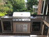 KoKoMo grill installed in an outdoor kitchen island with dark countertops, cabinets and glass-door appliances