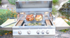 “KoKoMo grill cooking two rotisserie chickens above a tray of vegetables in a garden setting.”