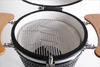 Open KoKoMo Kamado grill showing a partially lifted hinged cooking grate and white ceramic interior