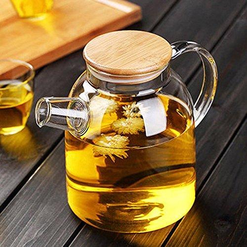 "Thermo Glass Teapot filled with blooming herbal tea on a wooden table"