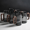 Set of glass mugs with wooden handles on a dark background