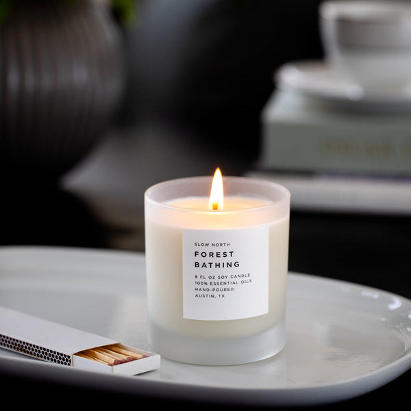 Close up of candle flame with botanical accents in the background