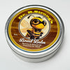 Closed 8 oz tin of Dr. B.Strong’s Board Balm with a bee-illustrated label on a white background