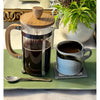 "Classic French Press coffee maker filled with fresh, rich coffee on a rustic table"