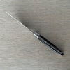 Top view of the ebony-handled pizza knife showing its slim blade profile, bee emblem and decorative metal spine