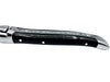 Side view of an ebony cheese knife handle with three metal rivets, polished end cap and decorative spine