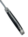 Close-up of a Laguiole en Aubrac ebony handle showing decorative metal spine detailing and the bee emblem