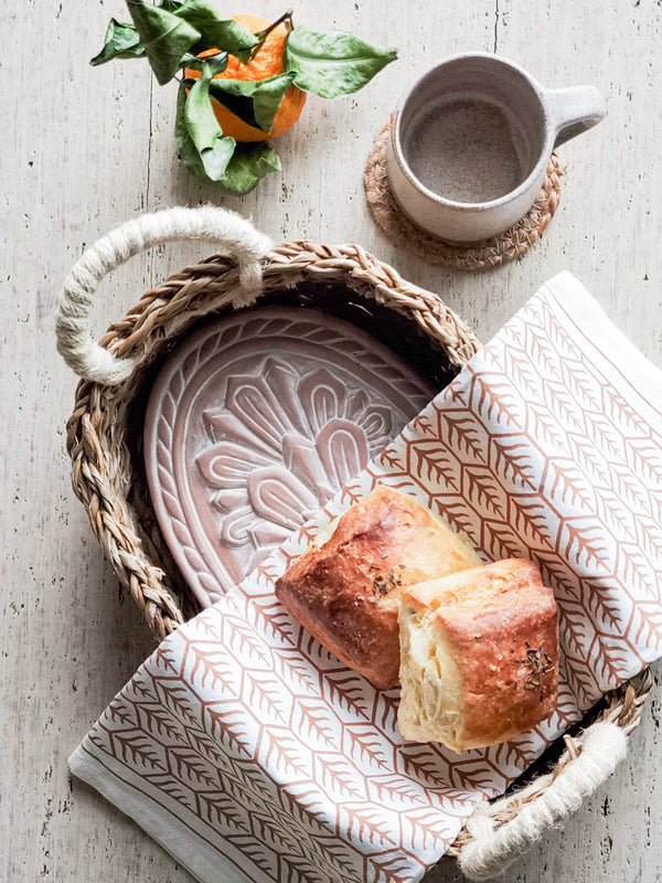 Warm crusty bread served with a terracotta warmer for a dinner setting"