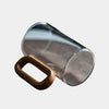 Round minimalist glass mug with walnut handle holding hot latte, eco-friendly kitchen drinkware