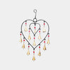Close-up of upcycled iron and brass heart chimes showing rustic artisan texture