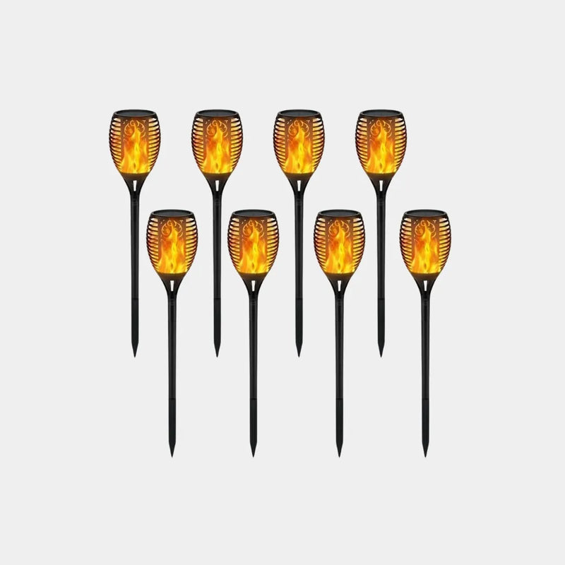Set of solar-powered flame-tipped garden lights on a white background