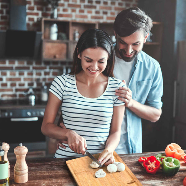 Man and woman preparing food together in a kitchen