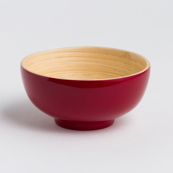 Red ceramic bowl with a beige interior on a light gray background