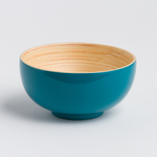 Teal ceramic bowl with wooden interior on a light gray background