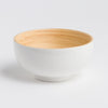 White ceramic bowl with a wooden interior on a light gray background