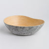 Bowl with gray marble exterior and wooden interior on a light gray background