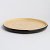 Round bamboo Tray with black rim and beige center on a light gray background