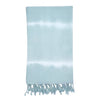 Ocean tie dye Turkish beach towel with hand-knotted tassels laid out on sand