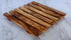 Close up detail of olive wood grain and natural edge trivet"