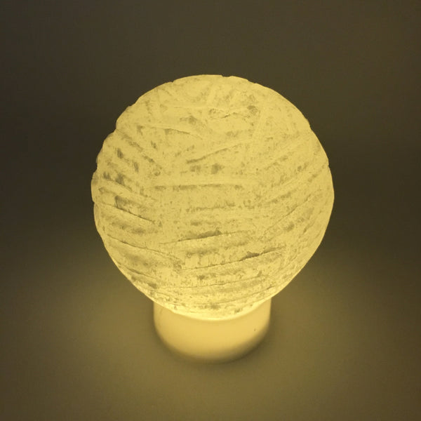 Close-up of translucent natural selenite crystal fibers and hand-cut bubble lamp texture