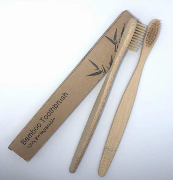 Two bamboo toothbrushes with a cardboard packaging
